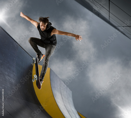 Fotografie Skater doing kickflip on the ramp