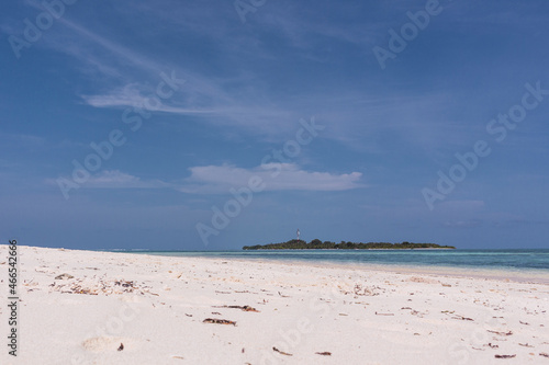 Playa paradisiaca soleada  agua cristalina y cielo azul  isla al fondo