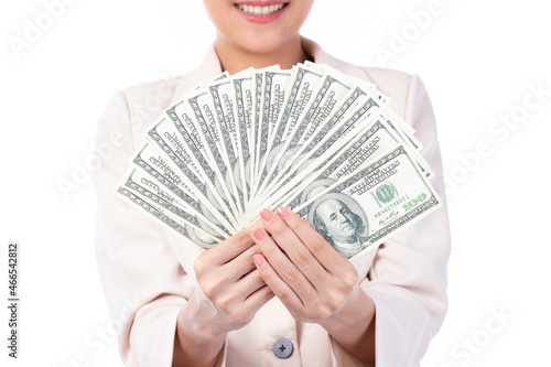 Portrait of a beautiful young Asian woman in suit holding dollar money banknotes, money exchange service. Studio shot isolated on white background.