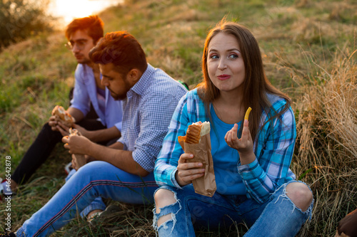 The young multi-ethnic students eating fastfood in campus