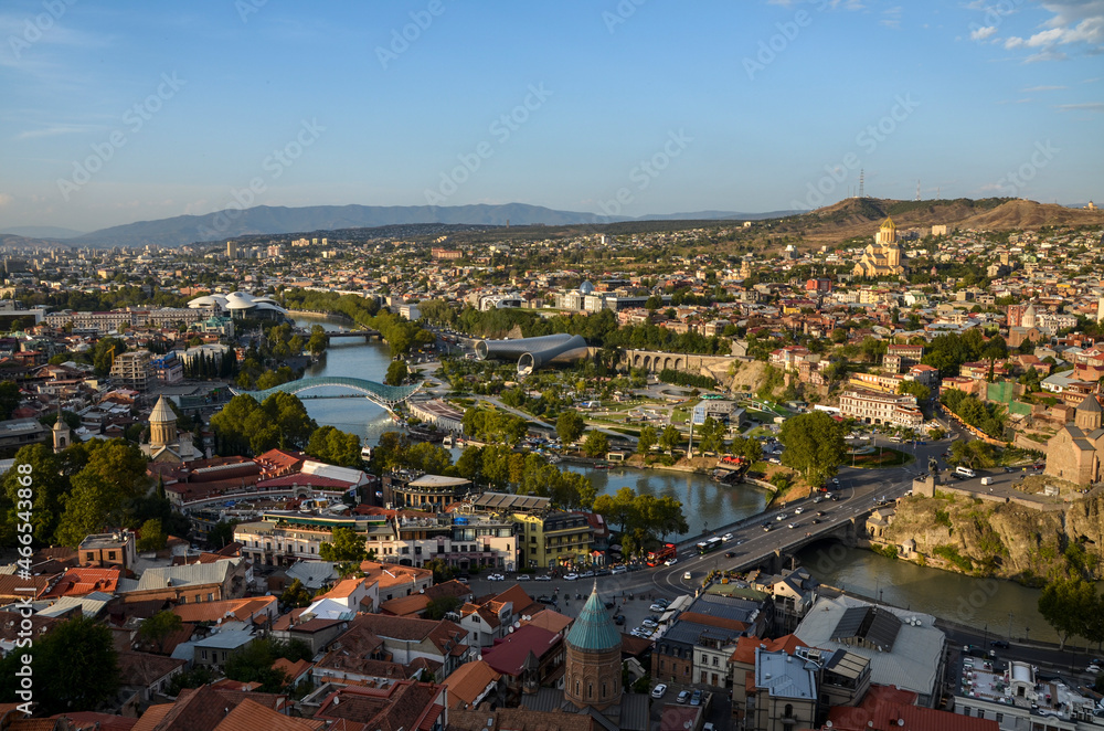 Panoramic view of Tbilisi old town with Kura river (Mtkvari) and mountains on background in light of sunset.  Famous georgian cityscape scene in Georgia.