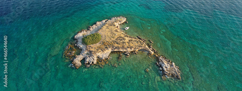 Aerial drone top down photo of small tropical exotic island covered in limestone with emerald sea © aerial-drone