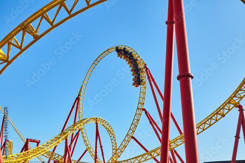Roller coaster in an amusement park against the blue sky. The concept of attractions and extreme recreation
