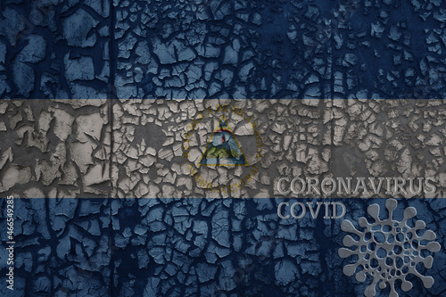 flag of nicaragua on a old metal rusty cracked wall with text coronavirus, covid, and virus picture.