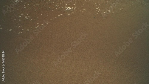 Sea waves breaking on sandy beach slow motion