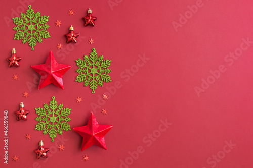 Flat lay border with snowflakes and christmas decoration on a red background