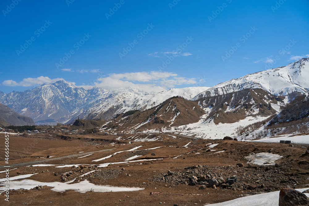 Obraz premium In a mountain valley, a breathtaking landscape of giant covered mountains in the background