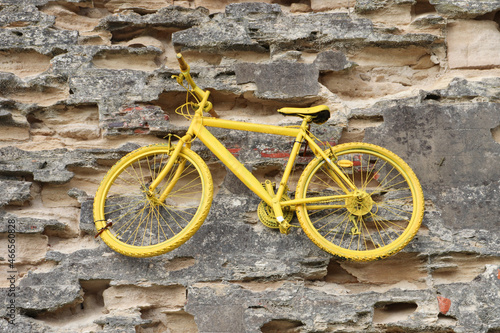 Vieux vélo jaune sur un mur