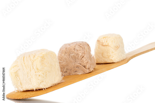 Three sweet cotton candy on a spatula made of wood, close-up, isolated on white.