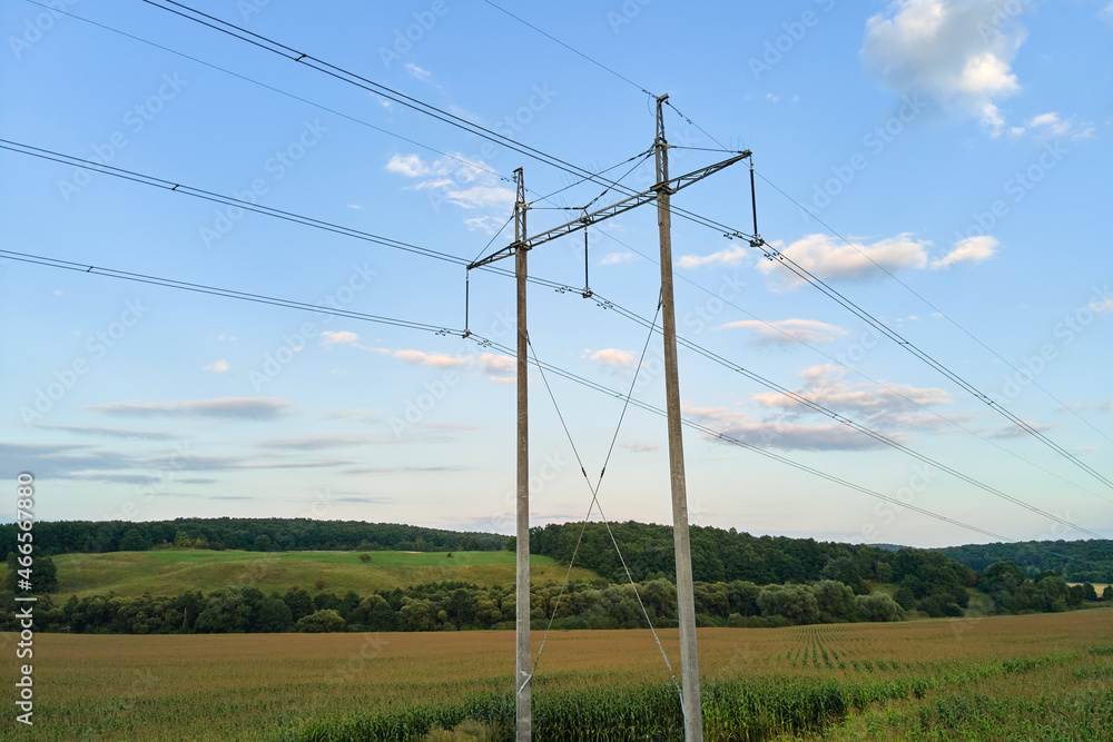 Tower with electric power lines for transfering high voltage electricity located in agricultural cornfield. Delivery of electrical energy concept. Tower with electric power lines for transfering high voltage electricity located in agricultural cornfield. Delivery of electrical energy concept.