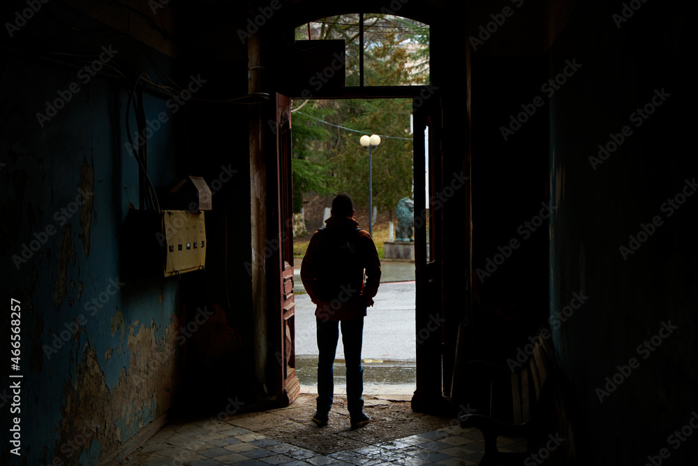 The guy is waiting in the front entrance of the old entrance when the rain stops The guy is waiting in the front entrance of the old entrance when the rain stops