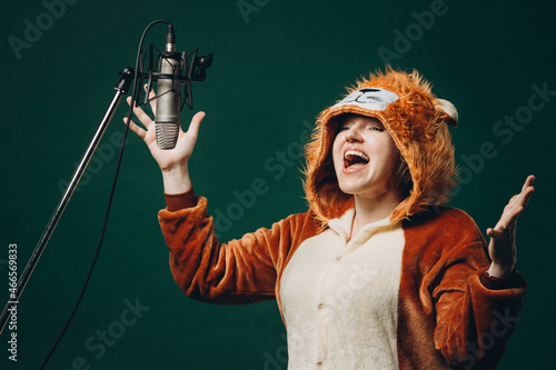 Woman prepares herself and a material before voice recording. Soundproof room for professional recording vocal. Voice artist works with material before dubbing or voice over process photo