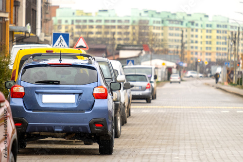 Cars parked in a row on a city street side.