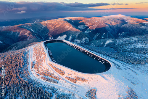 Pumped storage hydro plant "Dlouhe strane" in Jeseniky mountains during sunset. Aerial view on evening winter mountains. Third biggest pumped storage hydro plant in the world