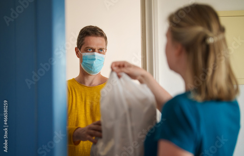 Masked man delivers food during pandemic.