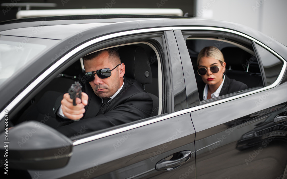 Agent bodyguard with gun protect celebrity VIP person in car