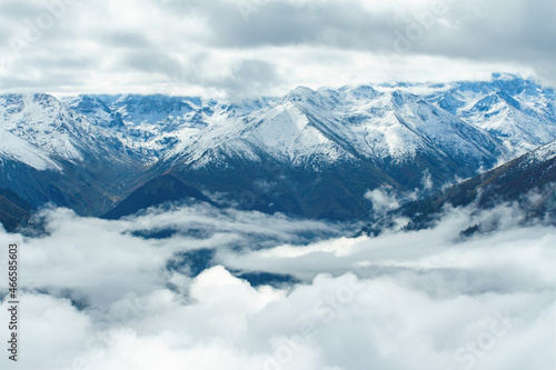 Aerial view above the clouds in mountain valley at morning. Wide banner © Leonid