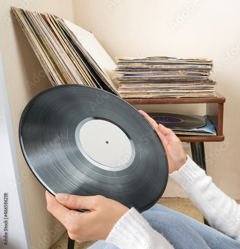 Woman choosing vinyl records at home for listening photo