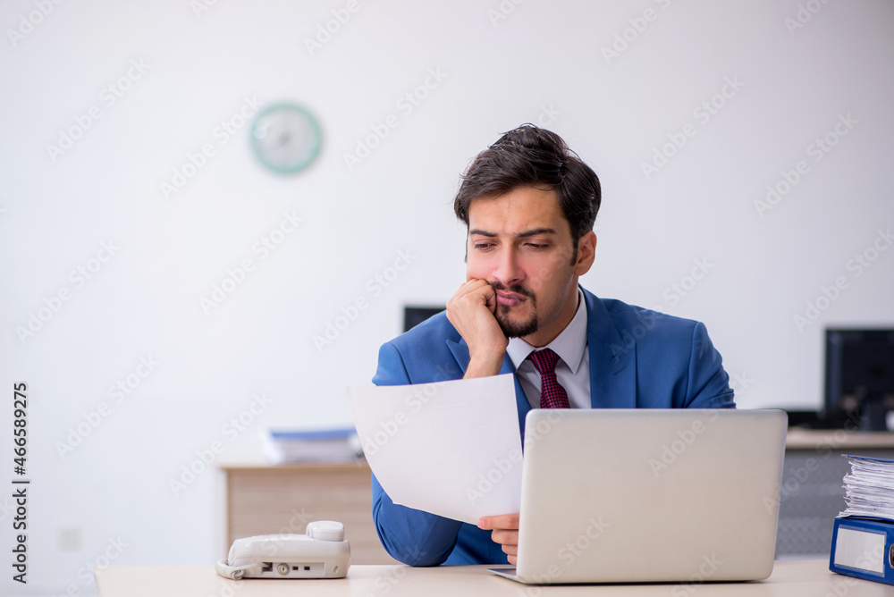 Young male employee working in the office Young male employee working in the office