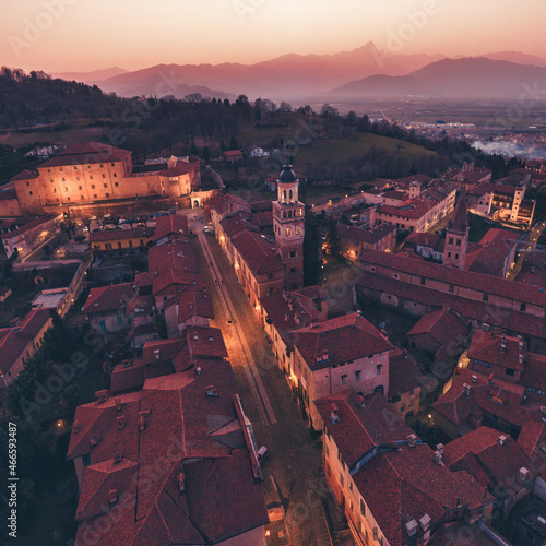 Veduta aerea del centro storico di Saluzzo dopo il tramonto, con il Monviso sullo sfondo