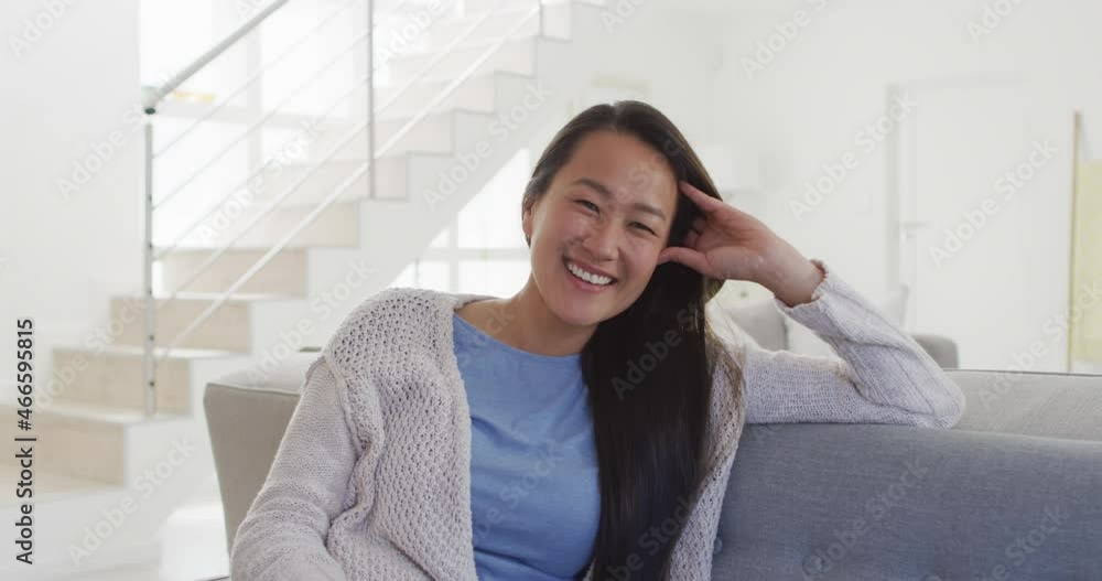 Happy asian woman sitting at sofa at home Happy asian woman sitting at sofa at home