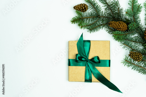 Christmas fir branch and cones. Gift box next to a fir branch on a white background. Christmas composition. Flat lay  top view  copy space