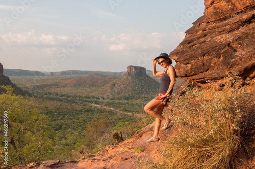 Lady at Chapada da Mesas in Maranhao, Brazil, at sunset as the sun hits off the red rocks