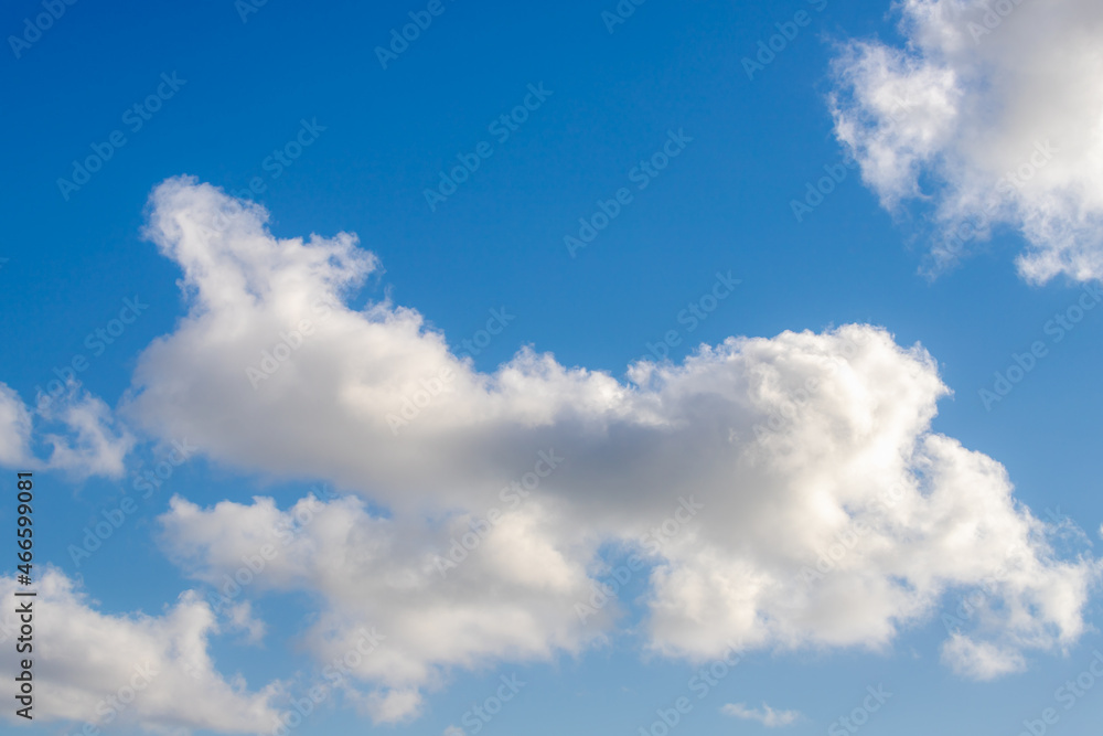 Fototapeta premium Beautiful white fluffy cloud floating in blue sky in sunny day, Cumulus are clouds which have flat bases and are often described as puffy, Horizon nature background.
