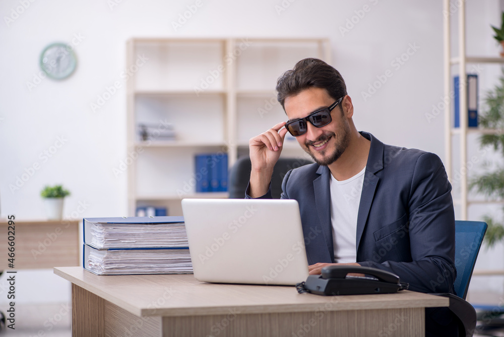 Young handsome employee working in the office Young handsome employee working in the office