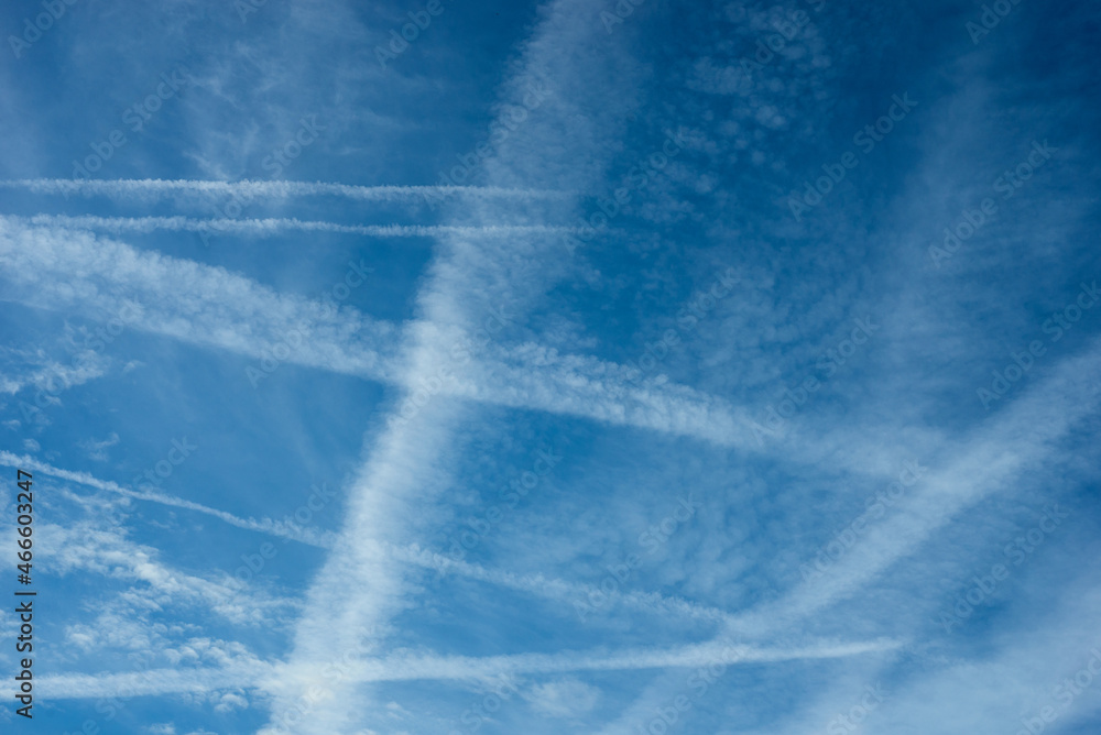 view of jet airplane contrails crossings in blue sky view of jet airplane contrails crossings in blue sky