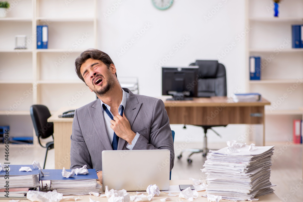 Young male employee and too much work in the office