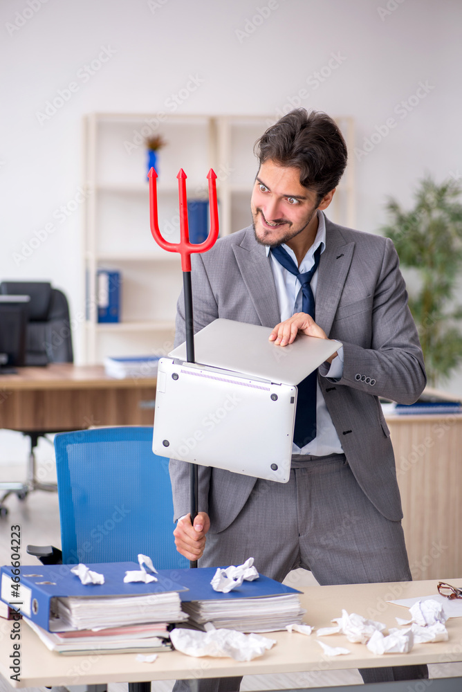 Young male employee and too much work in the office Young male employee and too much work in the office
