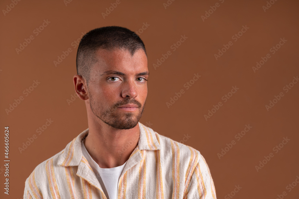 Studio portrait of a young man on a brown background