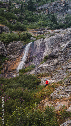 man hiking by waterfall