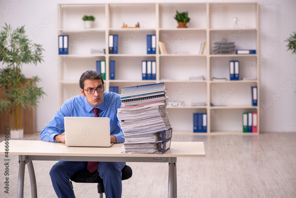 Young male employee unhappy with excessive work Young male employee unhappy with excessive work