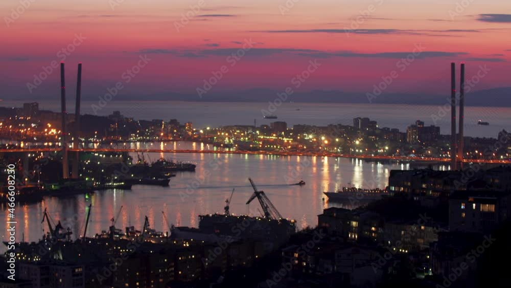 Timelapse of the cable-stayed Golden Bridge across the Zolotoy Rog (Golden Horn Bay). Boats are sailing along the bay. The sun is going down and the sky is turning dark. Sunset. Night cityscape Timelapse of the cable-stayed Golden Bridge across the Zolotoy Rog (Golden Horn Bay). Boats are sailing along the bay. The sun is going down and the sky is turning dark. Sunset. Night cityscape