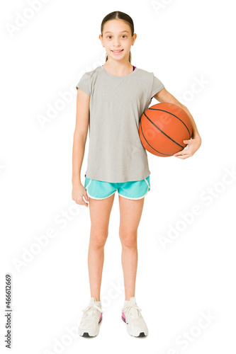 Cheerful girl taking basketball lessons