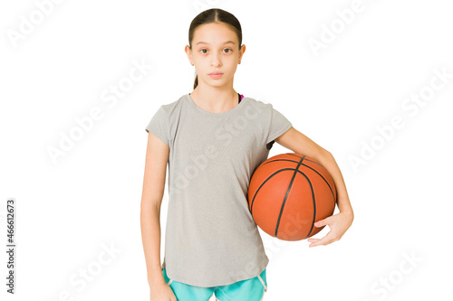 Competitive preteen playing basketball