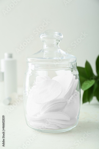 Glass jar with clean cotton pads on light table