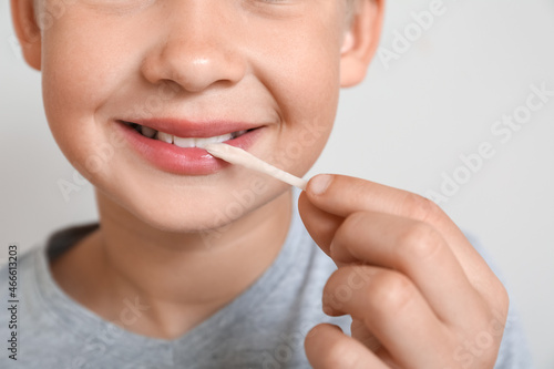 Little boy chewing gum on light background  closeup