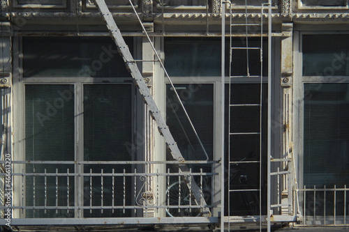 Close up of grey and white city building windows with fire escape and bicycle in Manhattan, New York City