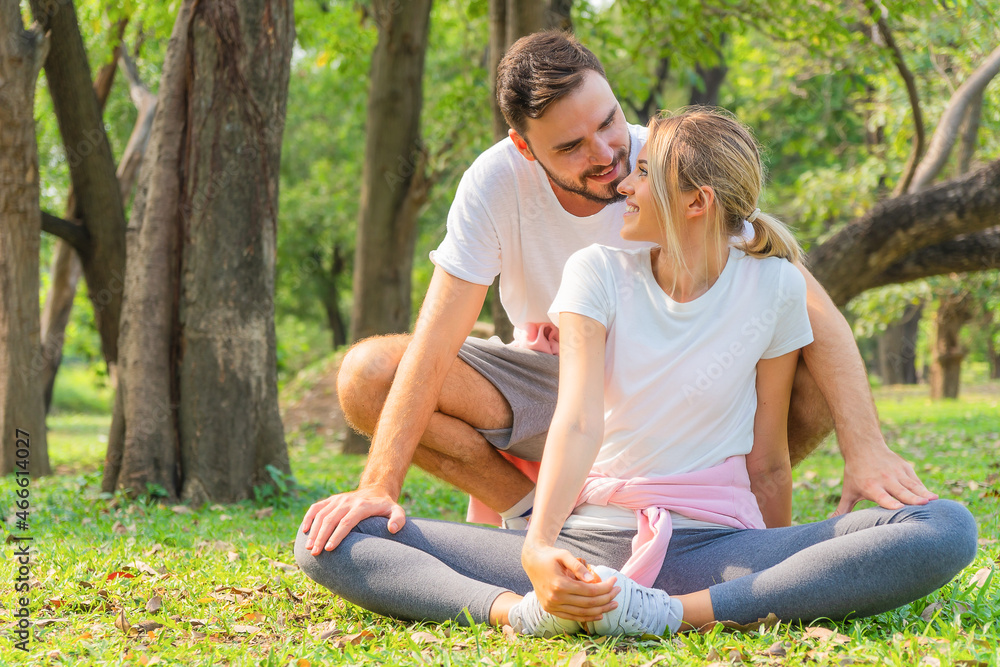 couple having stretching together before workout outdoors in park