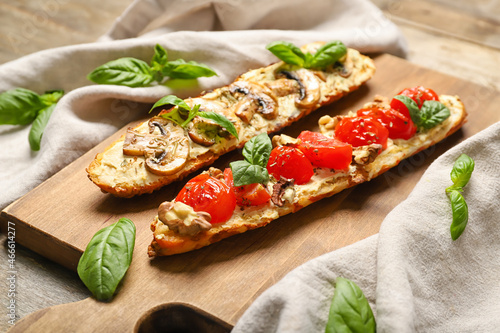 Board with delicious vegetarian bruschettas and spinach on table, closeup