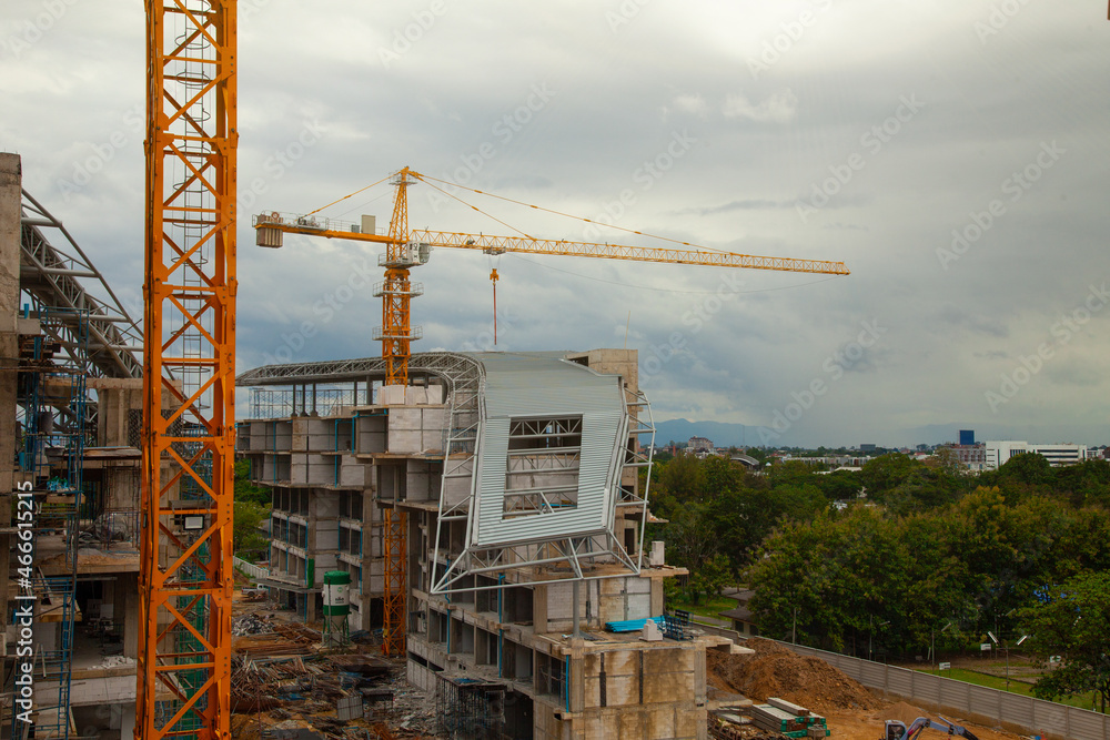 Construction site with yellow lifting crane and blue sky background.