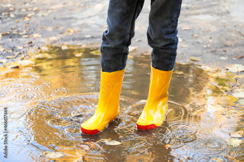 Child in gumboots outdoors on autumn day