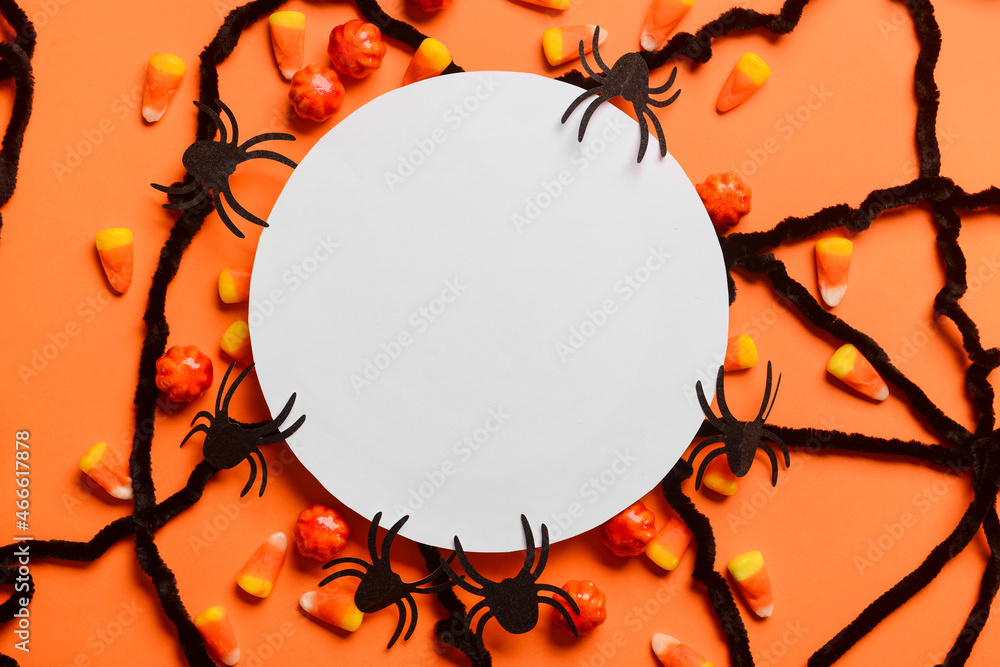 Blank paper sheet with candies and Halloween decor on red background