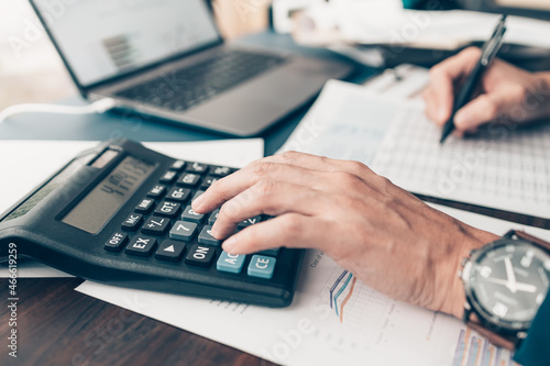 Financial businessman working on desk office using a calculator to calculate calculating corporate income tax data And analyzing charts of financial.  finance and accounting concept.