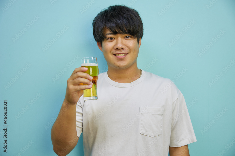 画面に向かって乾杯をする若い日本人男性 画面に向かって乾杯をする若い日本人男性