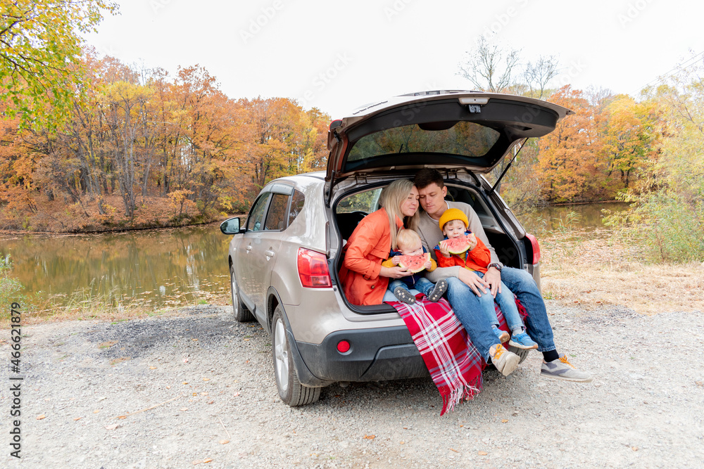 Young family had a picnic while sitting in the trunk of a car. Wellness concept. Young family had a picnic while sitting in the trunk of a car. Wellness concept.