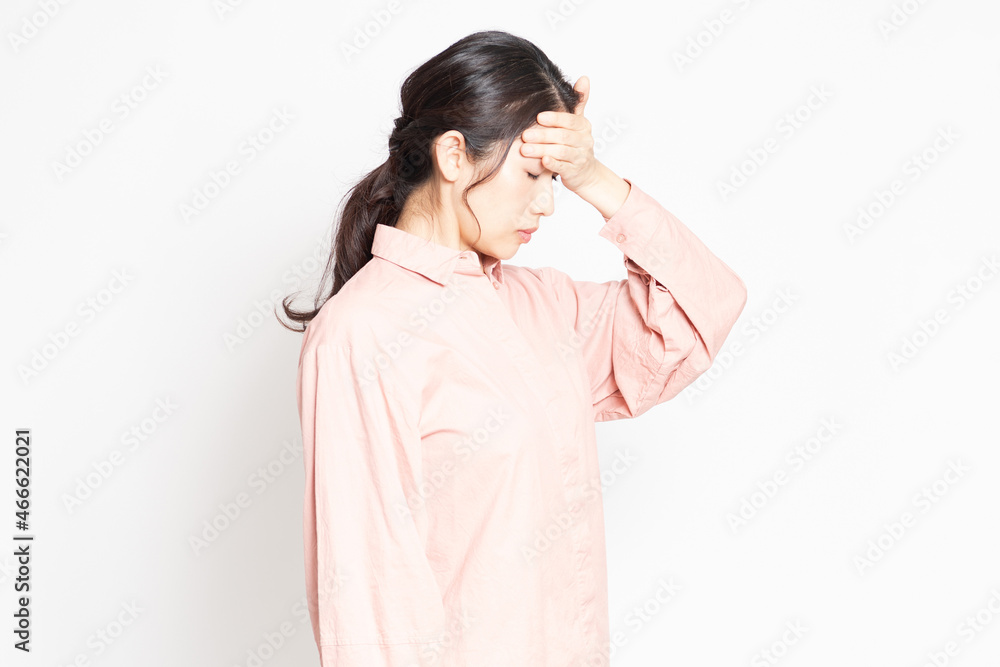 発熱でおでこに手を当てる女性